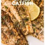 Baked catfish fillets with herbs and a lemon wedge on a white plate, recipe details included on the image.