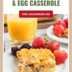 A plate with sausage and egg casserole, fresh berries, and a glass of orange juice.