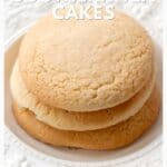 Three golden brown southern tea cakes stacked on a white plate with decorative edges.