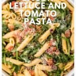 Bowl of penne pasta mixed with bacon, lettuce, tomato, and grated cheese, viewed from above.