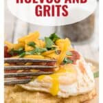 A fork cutting into a runny fried egg on top of grits, topped with cheese and herbs.