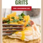 Close-up of huevos and grits topped with shredded cheese and herbs, with a fork cutting into a runny egg.