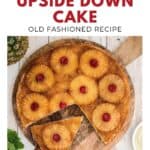 A pineapple upside down cake with cherries on top, one slice missing, on a wooden surface.