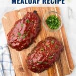 Two glazed meatloaves on a wooden board with chopped parsley in a small bowl, viewed from above.