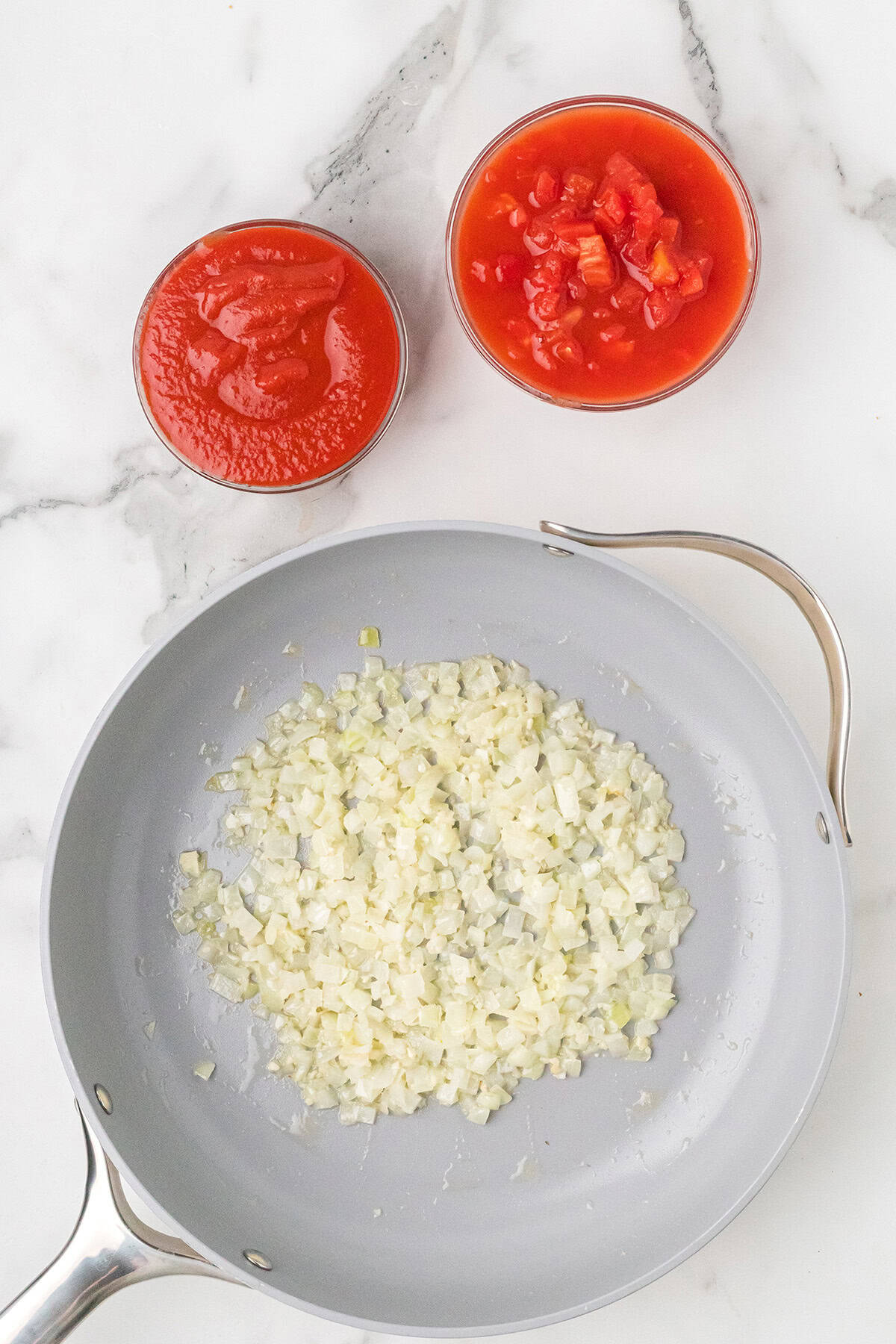 A pan with food in it and two bowls of sauce.