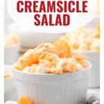 A white ramekin filled with orange creamsicle salad, topped with mandarin orange slices.