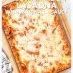 A baked pan of cheesy homemade lasagna with marinara sauce on a wooden tray, viewed from above.