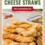A plate of golden, twisted puff pastry cheese straws stacked on a white plate.