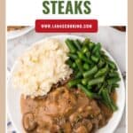 Plate with Salisbury steak in gravy, mashed potatoes, and green beans. Website URL and recipe title above the image.